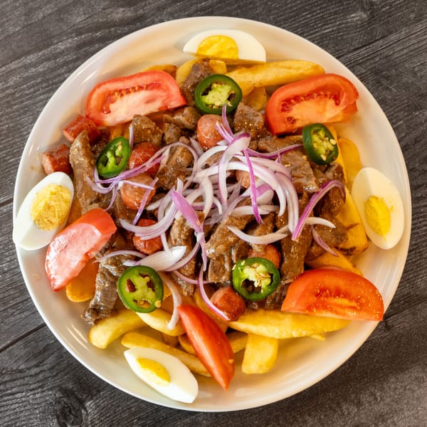 Bolivian Pique Macho with beef, fries, tomatoes, onions, jalapeños, and hard-boiled eggs.