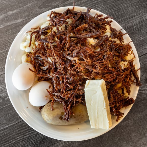 A Bolivian pique macho dish with shredded beef, corn, eggs, potato, and cheese.
